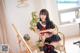 A woman in a school uniform is painting on a easel.