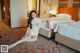 A woman sitting on a bed in a hotel room.