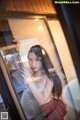 A woman standing in front of a glass door.