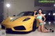 A woman in a bikini posing next to a yellow sports car.