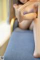 A woman sitting on a blue chair with her legs crossed.