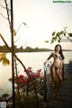 A woman in a black bikini standing on a wooden dock.