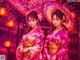 A couple of women in kimonos standing next to each other.