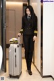 A woman in a pilot's uniform with a suitcase.