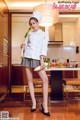 A woman in a chef's uniform holding a bunch of vegetables.