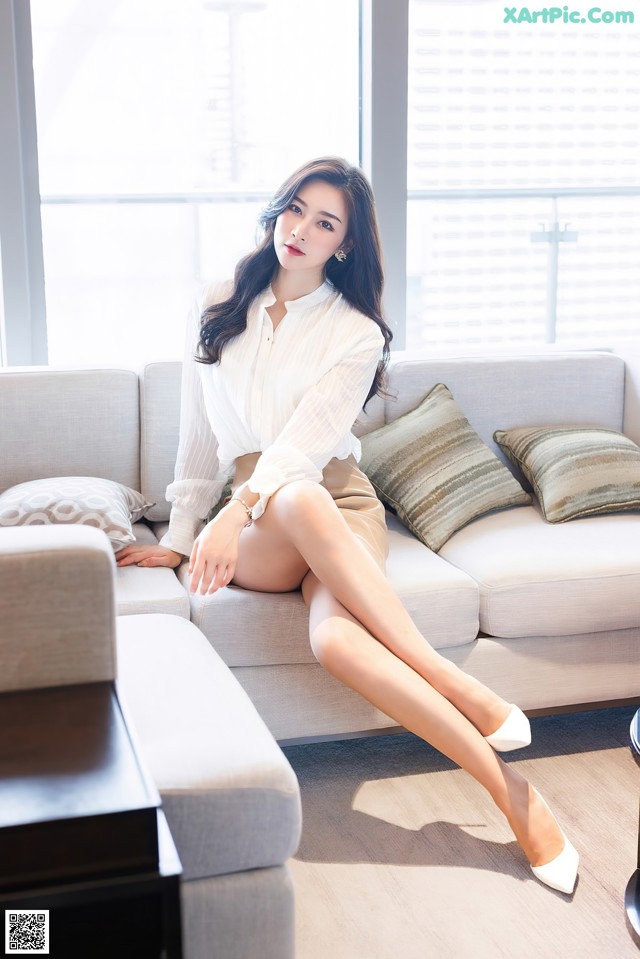 A woman sitting on a couch in a living room.