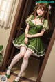 A woman in a green dress and white stockings posing for a picture.