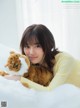 A woman laying on top of a bed holding a stuffed animal.