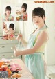 A woman in an apron preparing food in a kitchen.