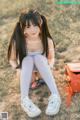 A young woman sitting on the ground with a backpack.