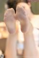 A woman's bare feet in front of a mirror.