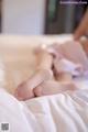 A woman laying on top of a bed with her feet up.