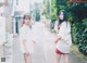 A couple of young women standing next to each other on a street.