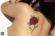 A woman with a rose tattoo on her back.