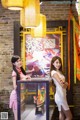 Two young women standing next to each other in front of a display case.