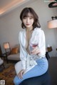 A woman sitting on a table holding a glass of wine.